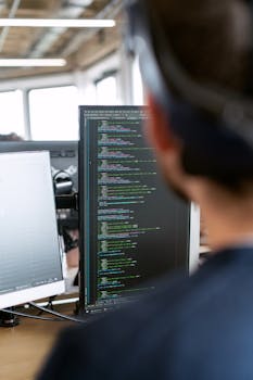 A male software engineer working on code in a modern office setting.